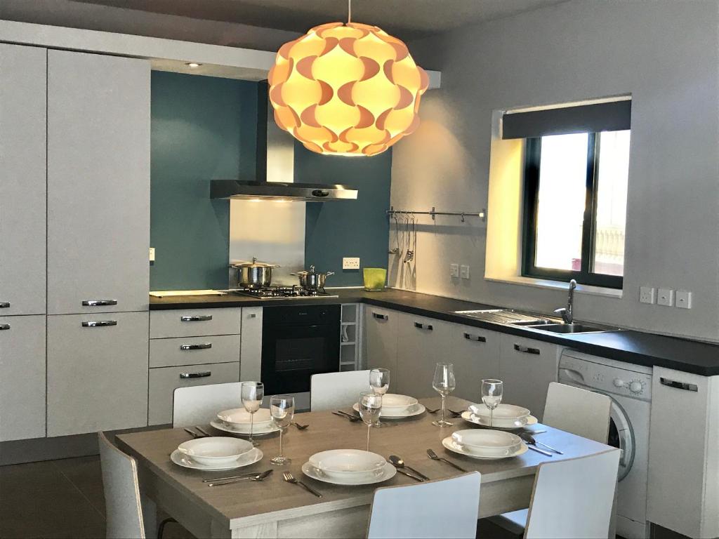 eine Küche mit einem Tisch und Stühlen sowie ein Esszimmer in der Unterkunft The Olive Gardens in Xagħra