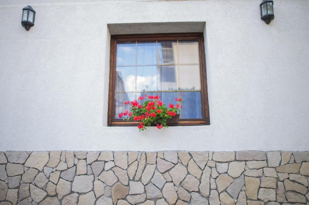 una ventana con una maceta de flores en una pared de piedra en Apartment Raza, en Konjic
