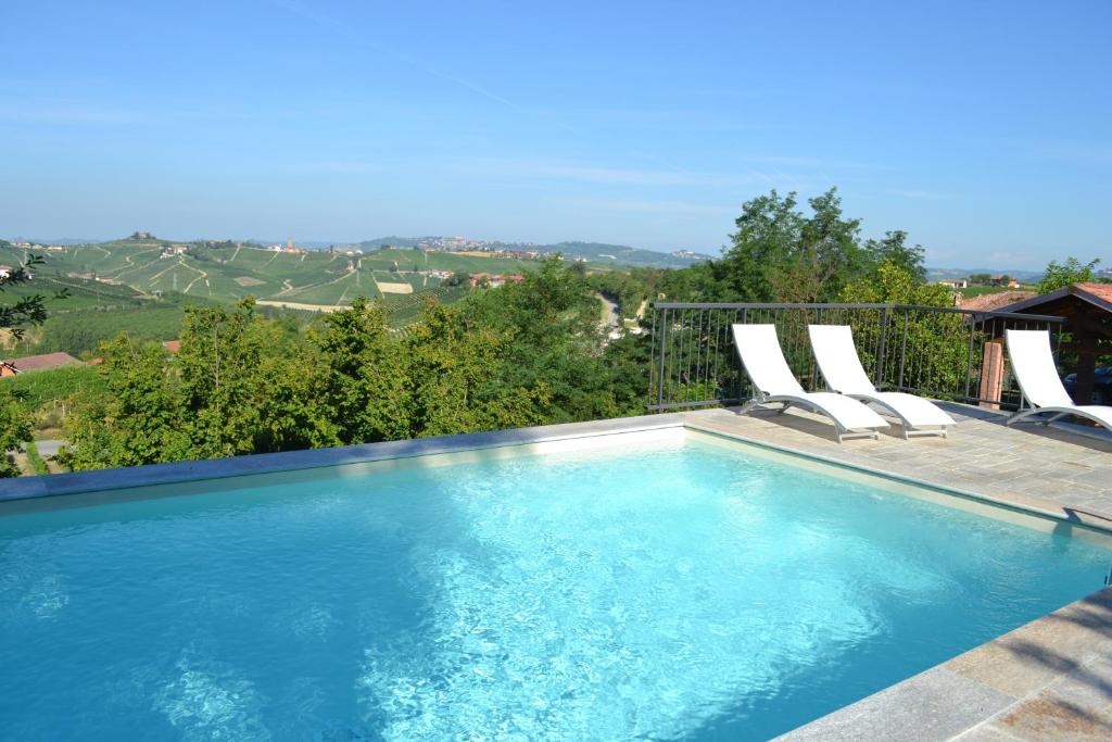 una piscina con sillas y vistas en Casa Caimotta, en Neive