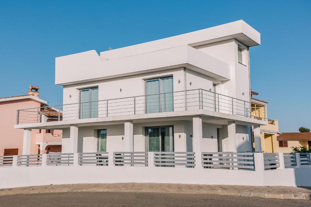 een wit huis met een balkon bij Villa Riviera in Portoscuso