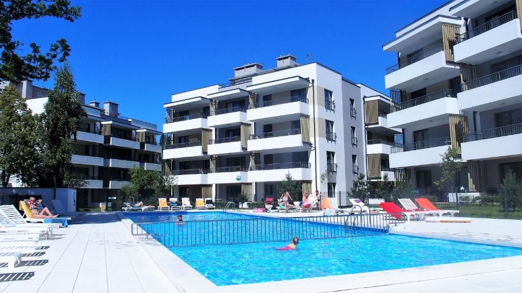 a swimming pool in front of a building at APD Apartments - Rezydencja Ustronie Morskie in Ustronie Morskie