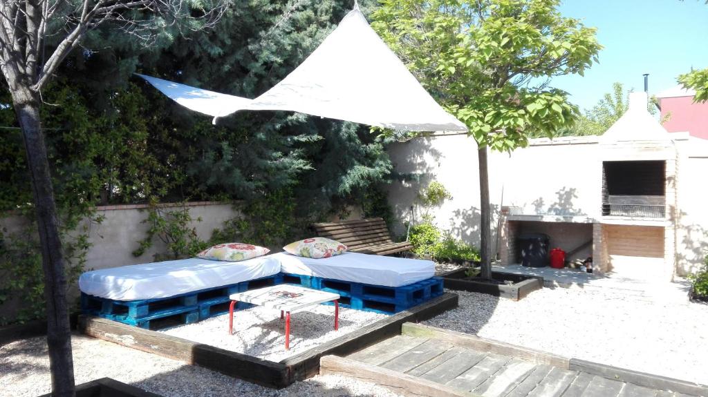 a picnic table in a yard with a white umbrella at Casa La Rosa de los Vientos in Cobisa
