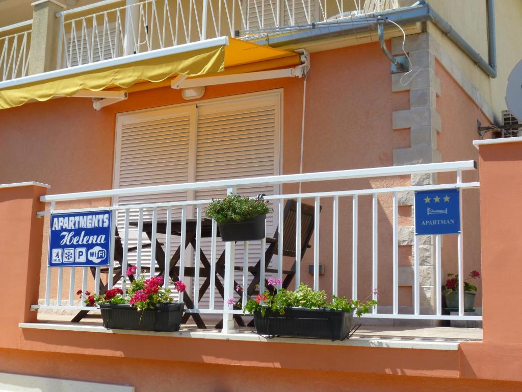 a balcony with potted plants on a building at Apartments Helena in Orebić