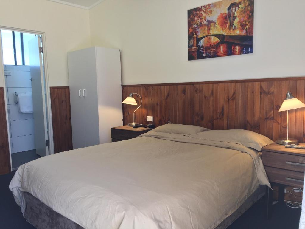 a bedroom with a large bed and two night stands at Lithgow Valley Motel in Lithgow