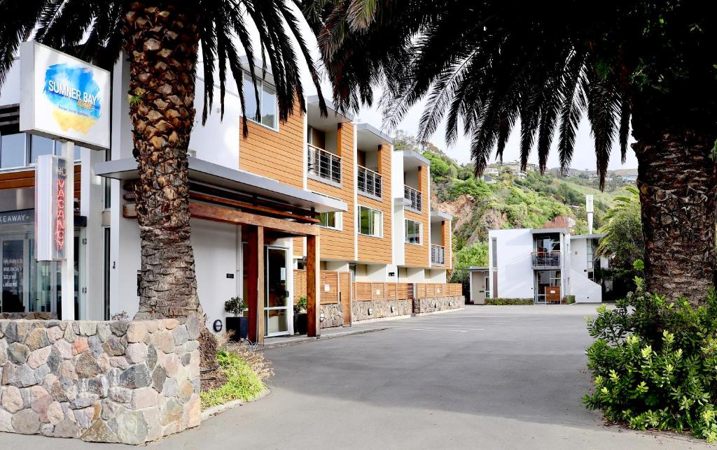 um edifício com uma palmeira ao lado de uma rua em Sumner Bay Motel em Christchurch