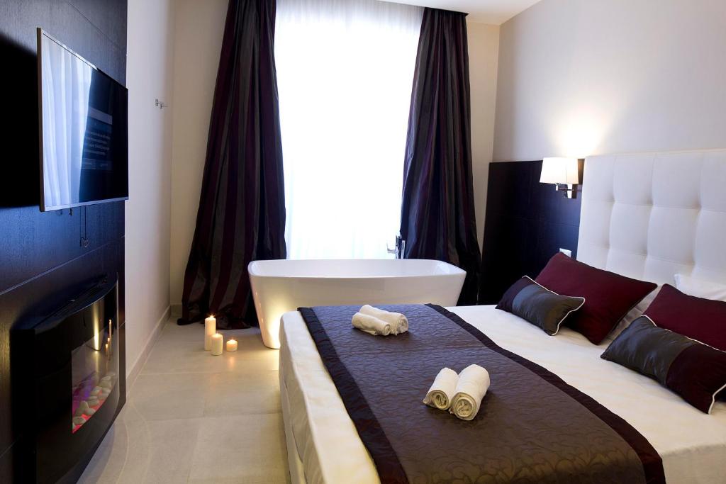 Een bed of bedden in een kamer bij Roman Holidays Boutique Hotel
