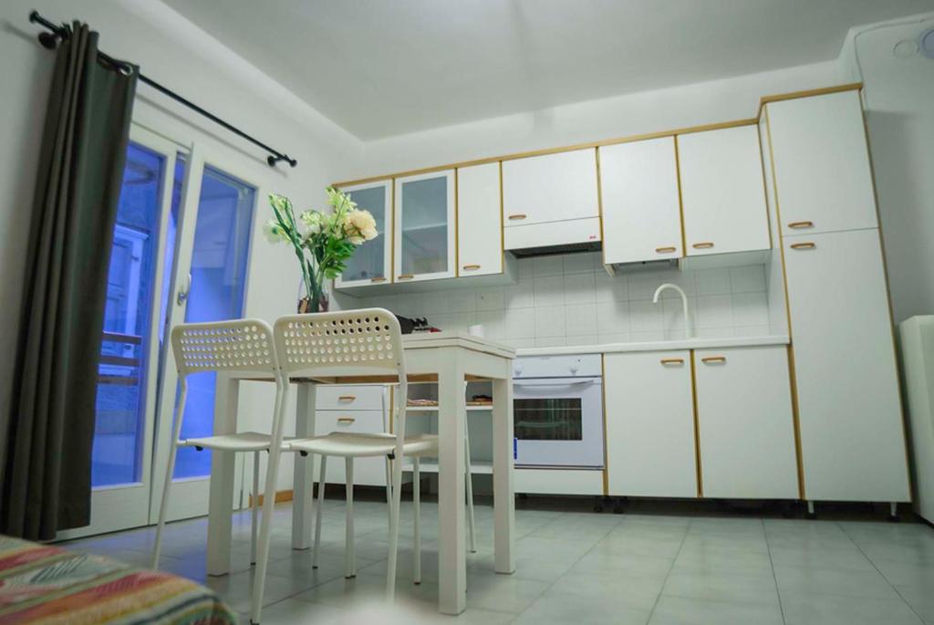 a kitchen with white cabinets and a table and chairs at SleepinGarda in Tenno