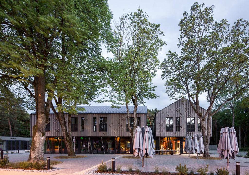 a building with trees and umbrellas in front of it at Melt in Palanga in Palanga