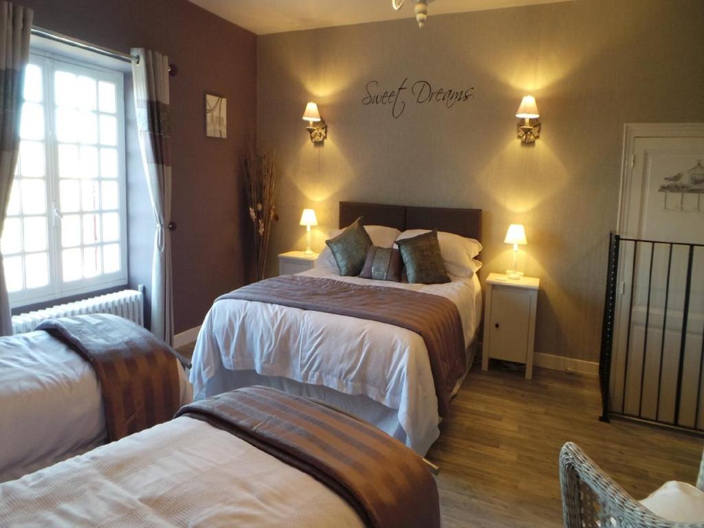 a bedroom with two beds and a sign on the wall at Le Montaigne in Saint-Alvère