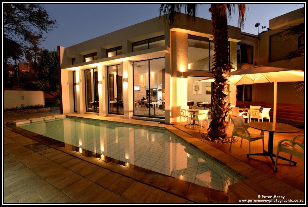 ein Haus mit einem Swimmingpool vor dem Haus in der Unterkunft The Lakes Boutique Lodge in Pretoria