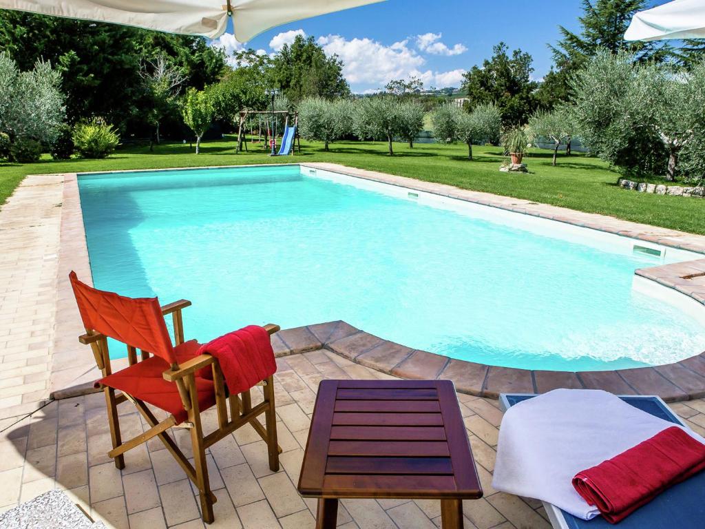 una piscina con una silla, una mesa y una silla en Detached Apartment near Todi with Private Pool, en Fanciullata