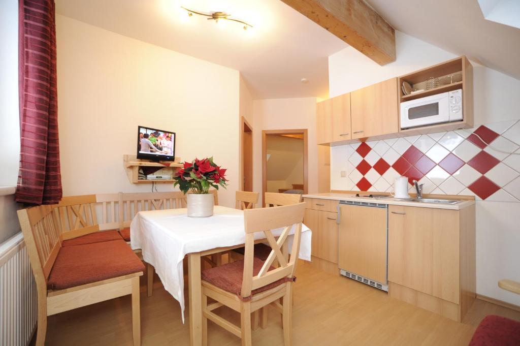 - une cuisine et une salle à manger avec une table et des chaises dans l'établissement Appartementhaus Hochegg, à Lachtal
