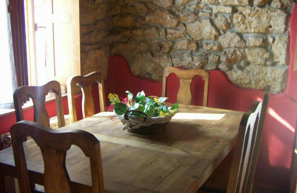 a wooden table with chairs and a bowl of flowers on it at Casa De Aldea Fonfria in Las Vegas De Cardeo