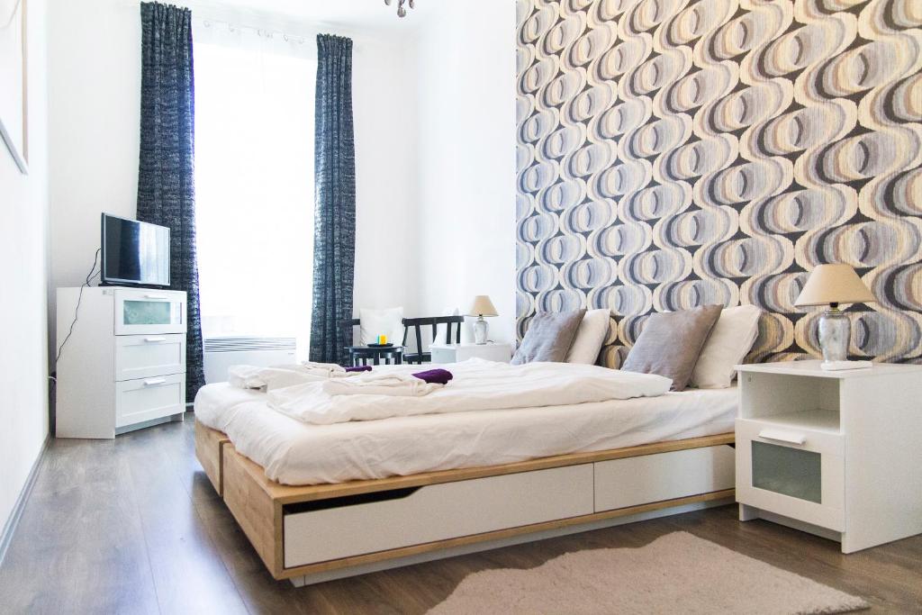 ein Schlafzimmer mit einem großen Bett mit einem Holzrahmen in der Unterkunft Bright 2BR&AC apt at Astoria in Budapest