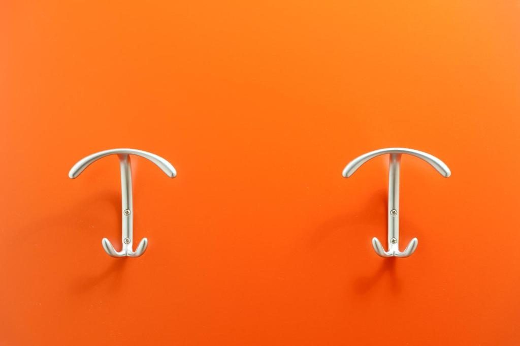two metal hooks on an orange background at Hotel Mediterraneo in Sottomarina