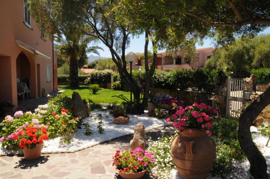 un giardino fiorito in vasi e una recinzione di Residence Le Colonnine a San Teodoro