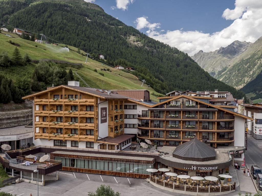 a view of a hotel with mountains in the background at Hotel Tyrolerhof in Sölden