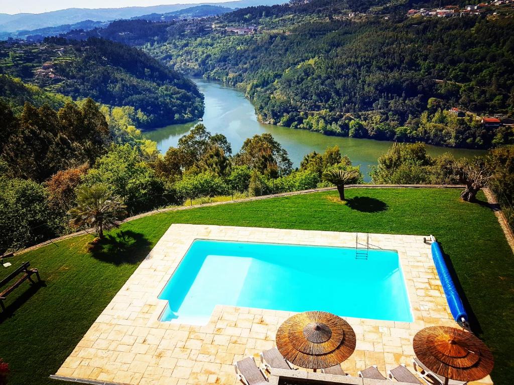an aerial view of a swimming pool with a river at Quinta das Tílias Douro Valley in Cabaça