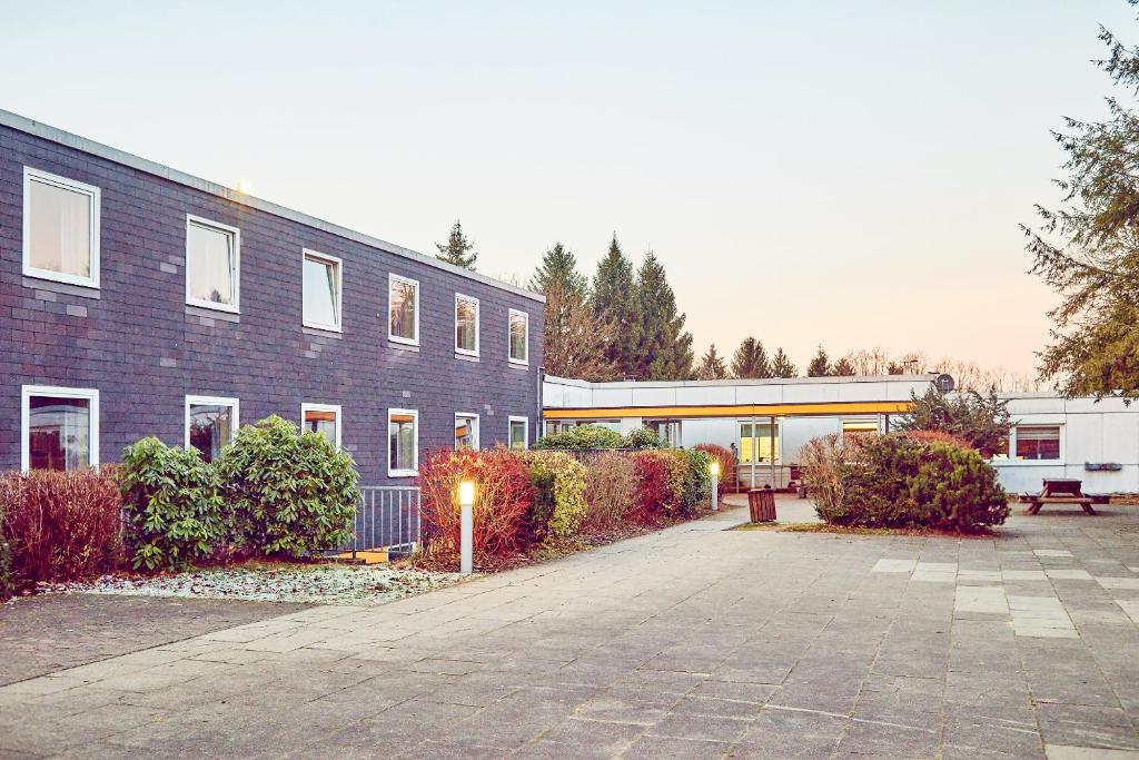 a large brick building with a bench in front of it at DJH Jugendherberge Biggesee in Olpe