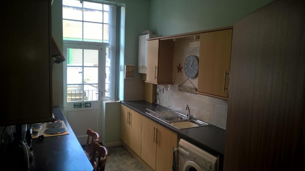 a kitchen with wooden cabinets and a sink and a window at Crown Spa Apartment 13 in Scarborough