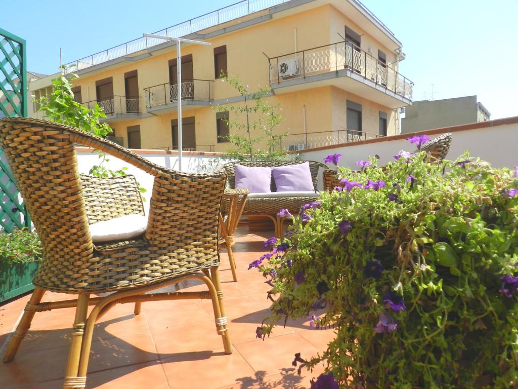 a patio with two chairs and flowers on a balcony at B&B Gelsomino in Noto