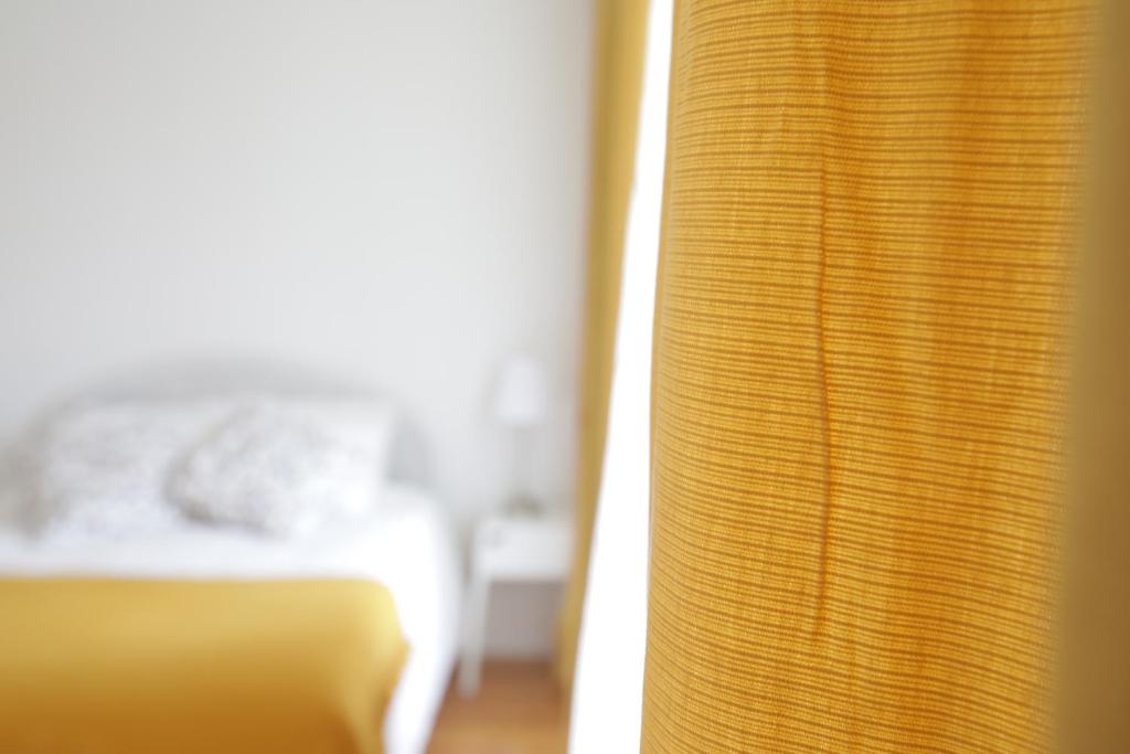 リスボンにあるArroios de Paixaoのベッド1台、窓(カーテン付)が備わる客室です。