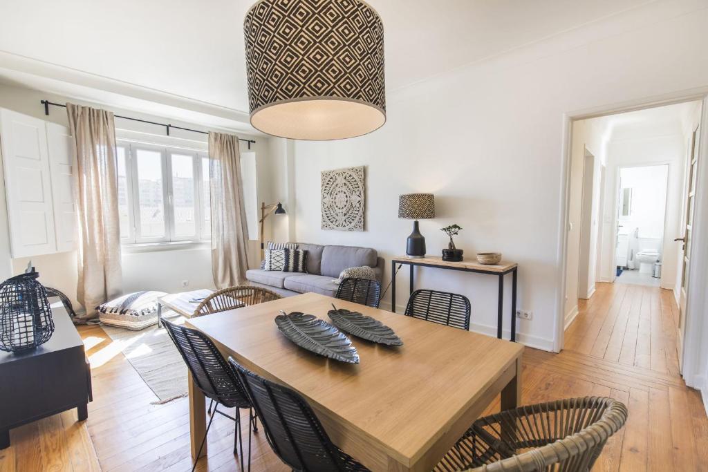 - une salle à manger et un salon avec une table et des chaises dans l'établissement LovelyStay - Bonsai Light and Comfort flat, à Lisbonne