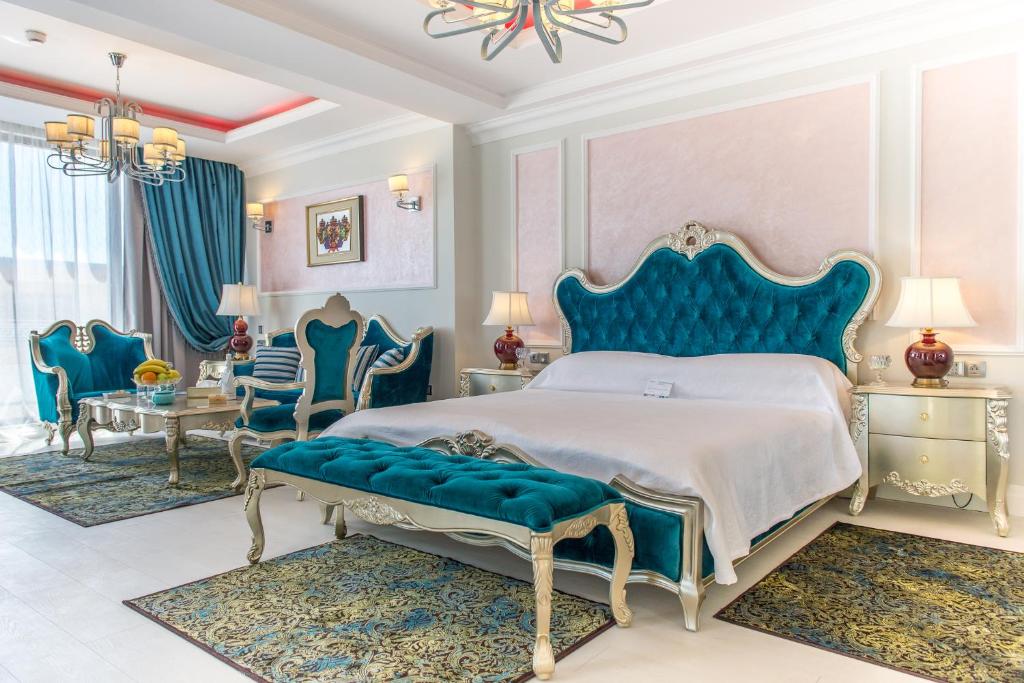 een slaapkamer met een blauw bed en blauwe stoelen bij Phoenicia Royal Hotel in Mamaia Nord – Năvodari