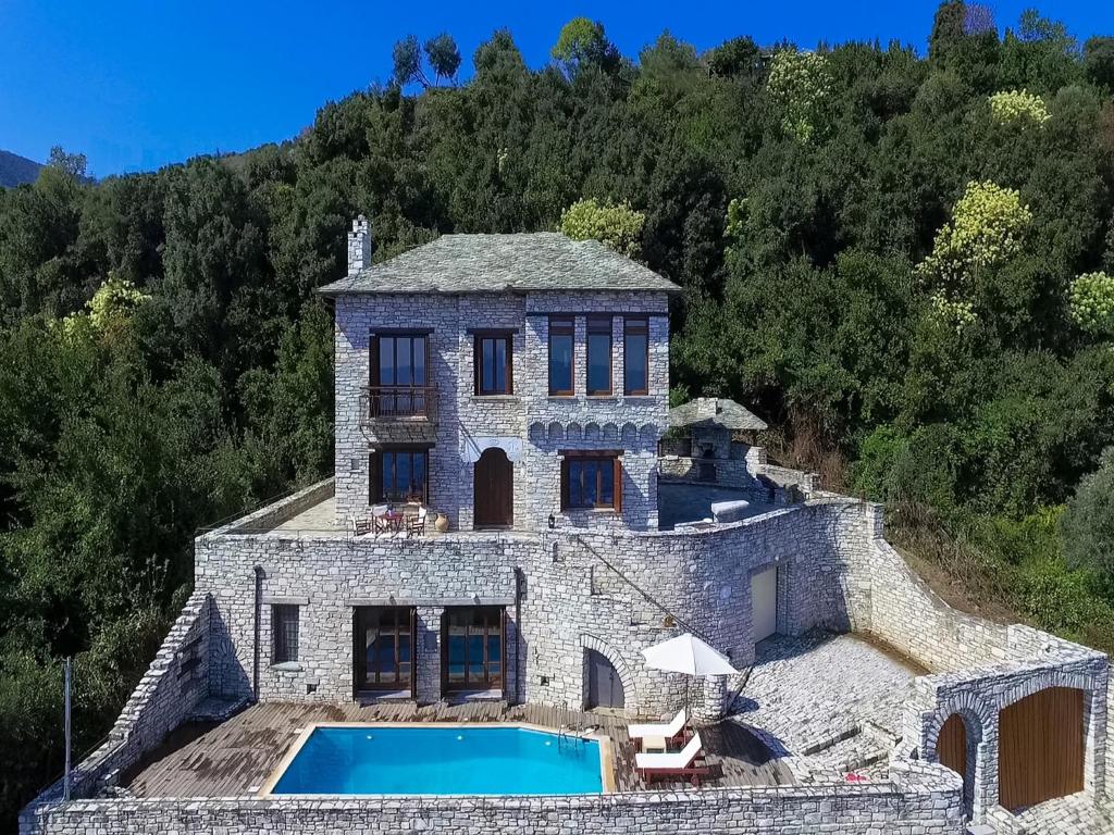 an aerial view of a stone house with a swimming pool at Dionysos Villa in Keramídhion