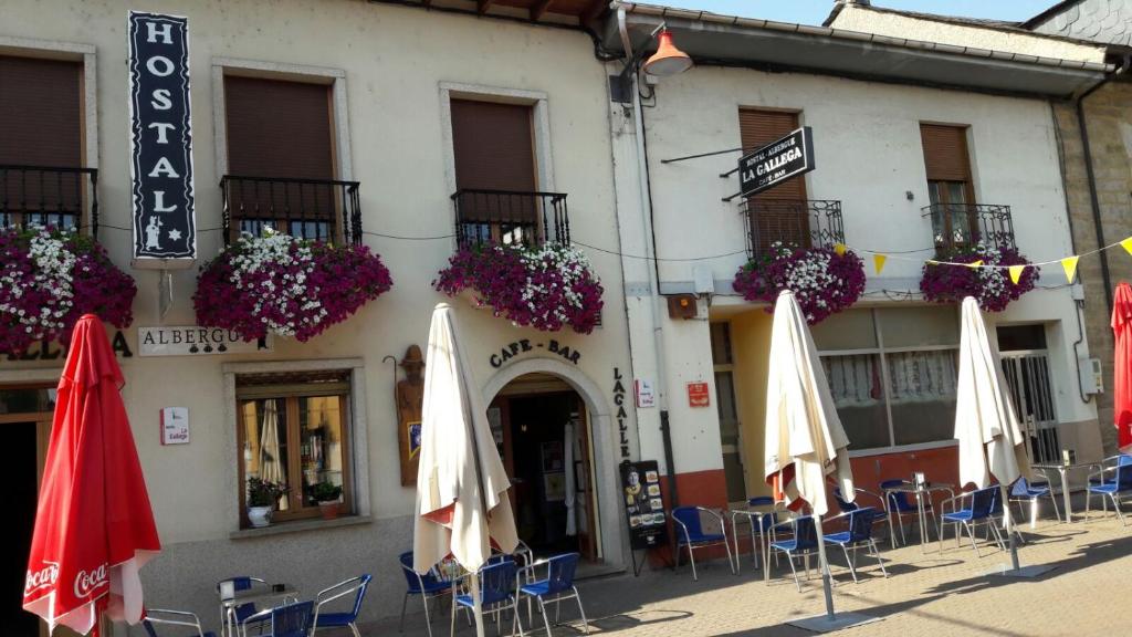 un grupo de sombrillas y sillas frente a un edificio en La Gallega, en Cacabelos