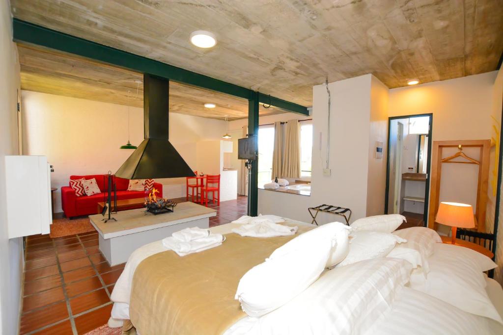 a bedroom with a large bed and a living room at Pousada Encontro da Pedra in Monte Verde