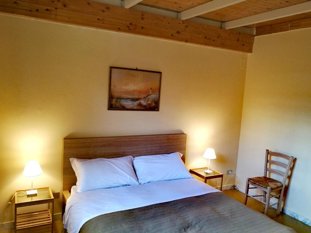 una camera con un letto con due lampade e una sedia di Brezzolina Apartment with parking a Bitonto