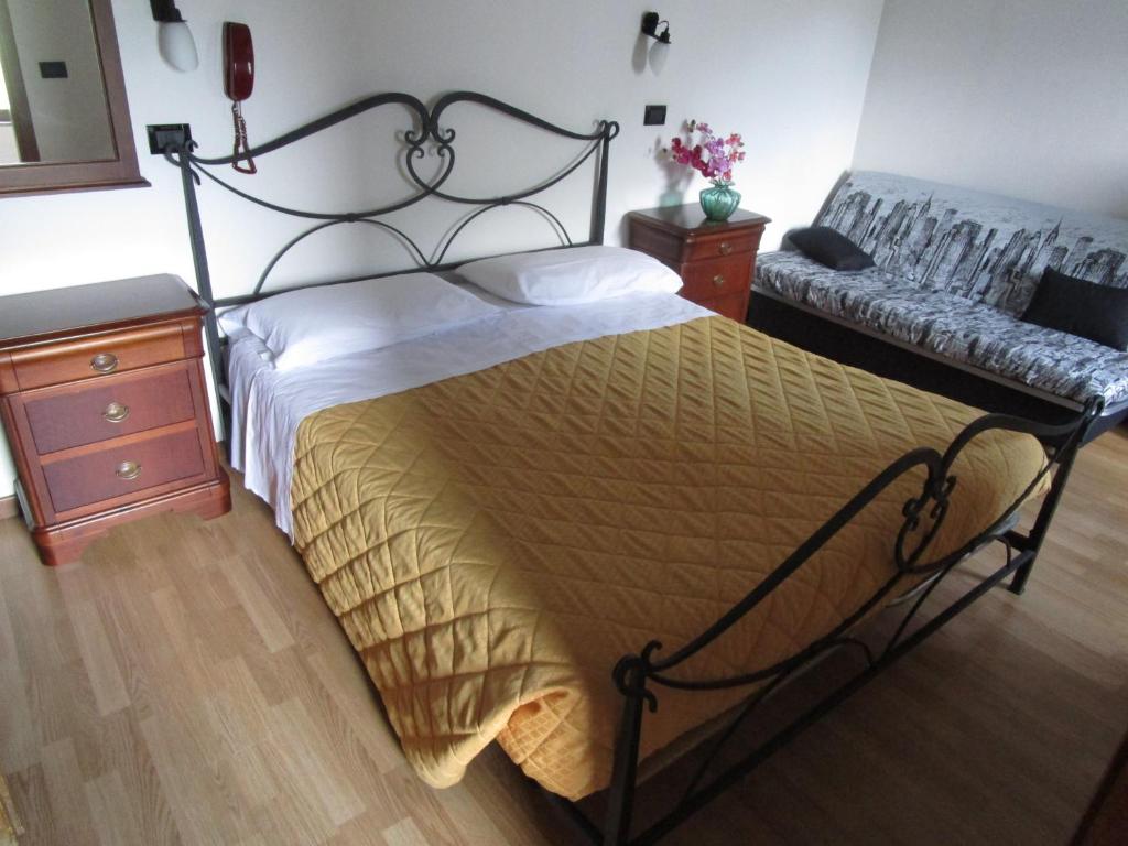 フィウマルボにあるAlbergo Val di Luceのベッドルーム(大型ベッド1台、ソファ付)