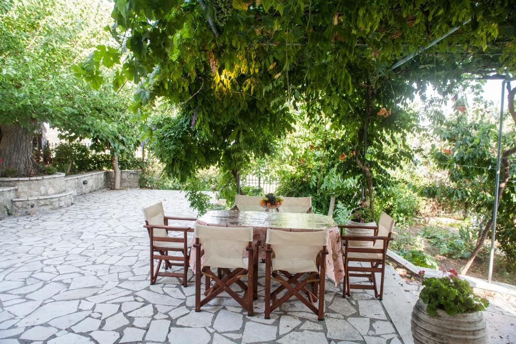 una mesa y sillas en un patio bajo un árbol en Villa Ilias, en Pinakokhórion