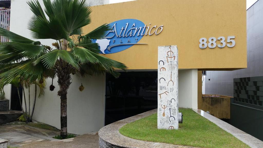 un edificio con una palma di fronte di Atlântico Flat 104 e 116 a Natal