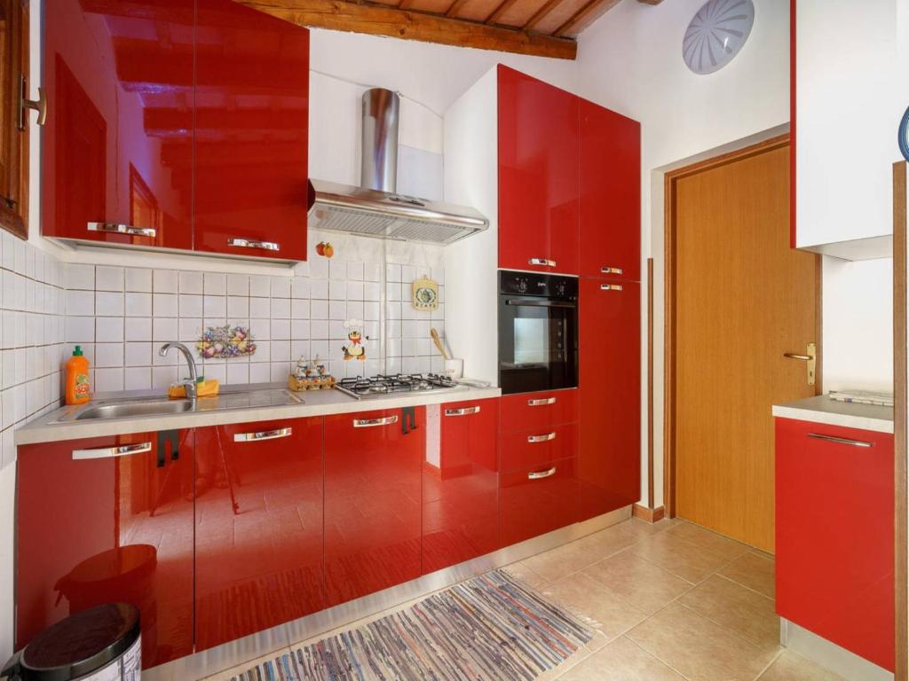 a red kitchen with red cabinets and a sink at Casa Aloha San Vito Lo Capo in San Vito lo Capo