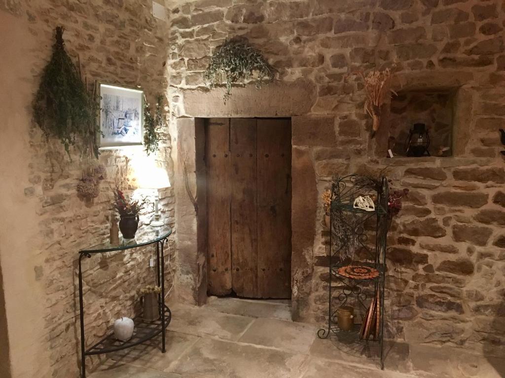 a room with a wooden door in a stone wall at Les Chambres d'hotes de Laurette in Bertrambois