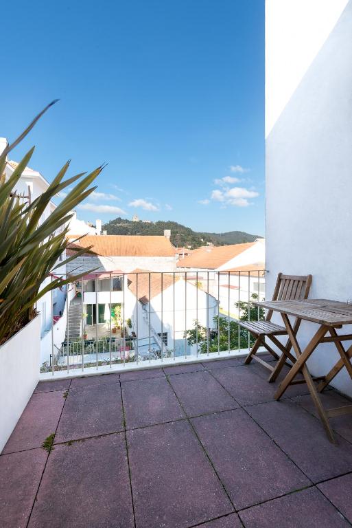 een balkon met een houten tafel en een bank bij Pensao O Laranjeira in Viana do Castelo