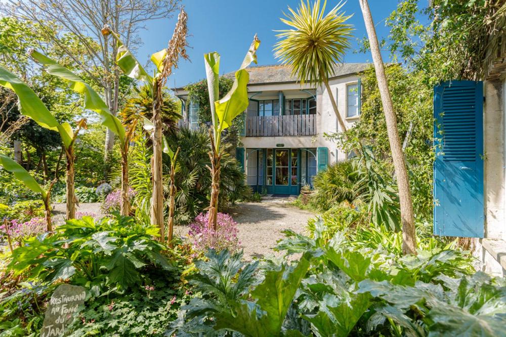 uma casa antiga com um jardim em frente em Hotel de France em Saint-Vaast-la-Hougue