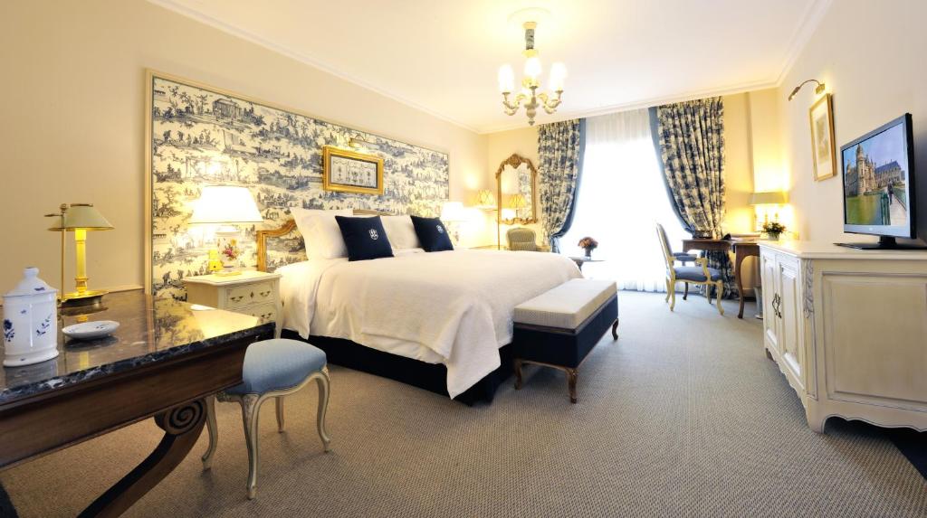 - une chambre d'hôtel avec un lit et un bureau dans l'établissement Auberge du Jeu de Paume, à Chantilly