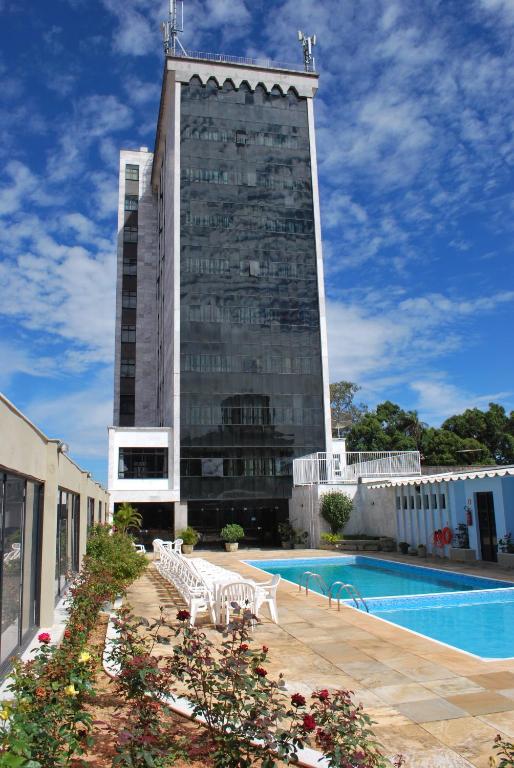a building with a swimming pool and a building at Lucape Palace Hotel in Barbacena