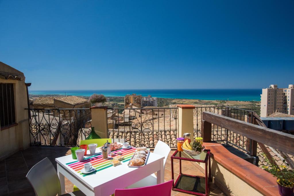 a table on a balcony with a view of the ocean at La terrazza di Girgenti in Agrigento
