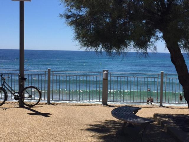 uma bicicleta estacionada ao lado de uma cerca ao lado da praia em Sanary em Sanary-sur-Mer