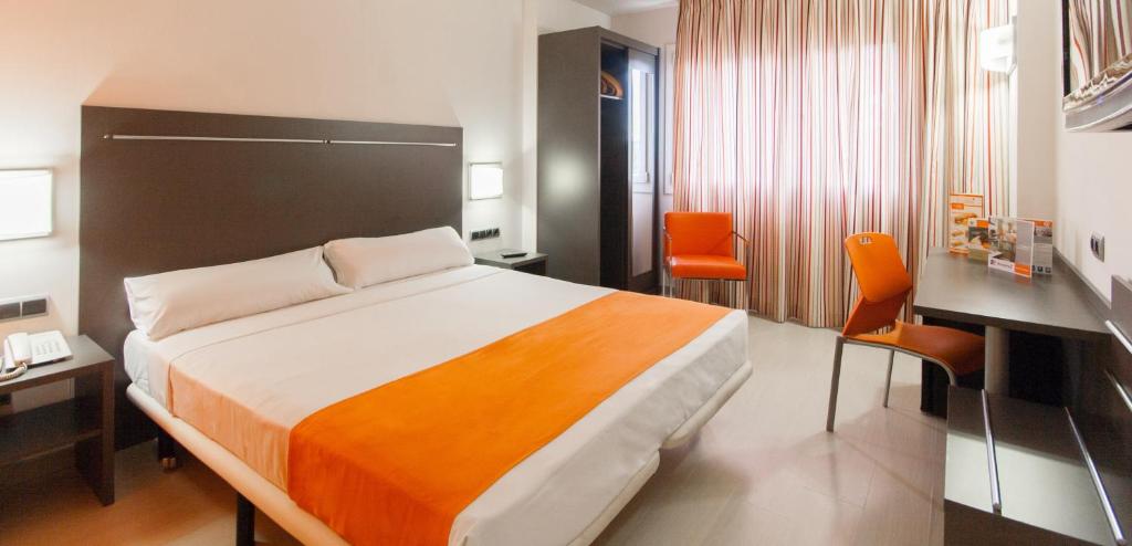 a hotel room with a bed and a desk at Hotel H2 Avila in Ávila