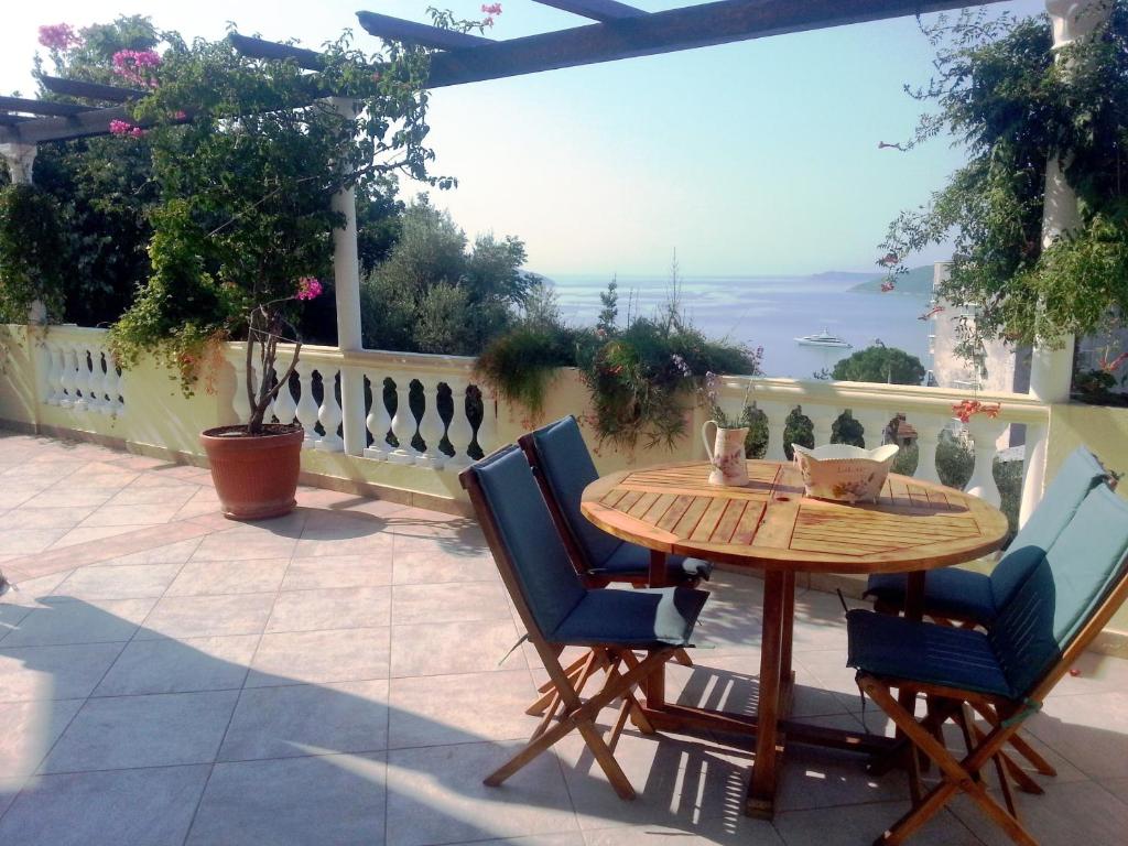 einen Holztisch und Stühle auf einer Terrasse in der Unterkunft Apartments Herceg Novi in Herceg-Novi