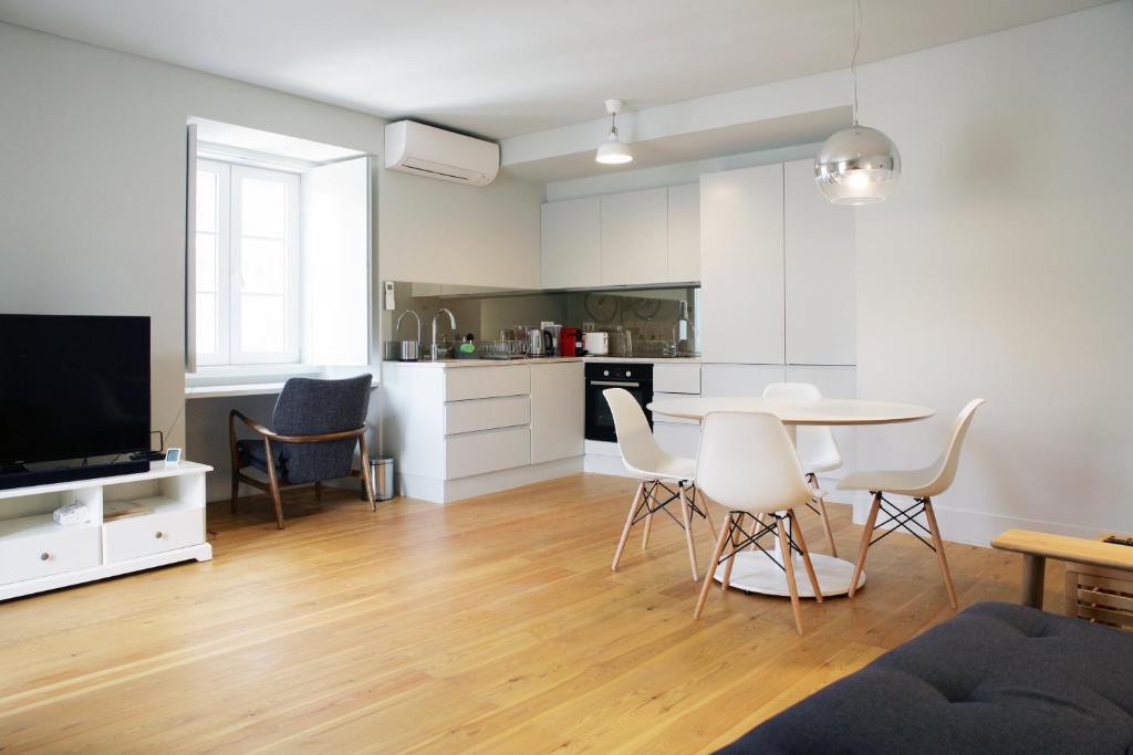uma sala de estar com mesa e cadeiras e uma cozinha em Boavista Bike Apartment em Lisboa