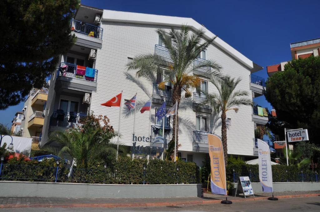 a hotel with palm trees in front of a building at Hotel Lunay in Antalya