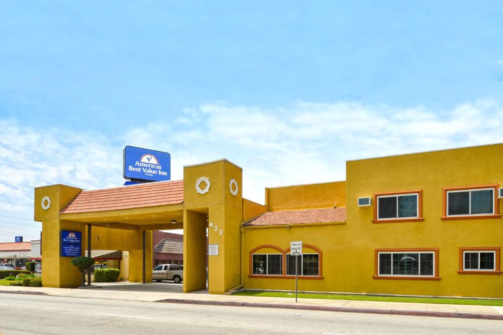 un bâtiment jaune avec un panneau en haut dans l'établissement Americas Best Value Inn - Azusa/Pasadena, à Azusa