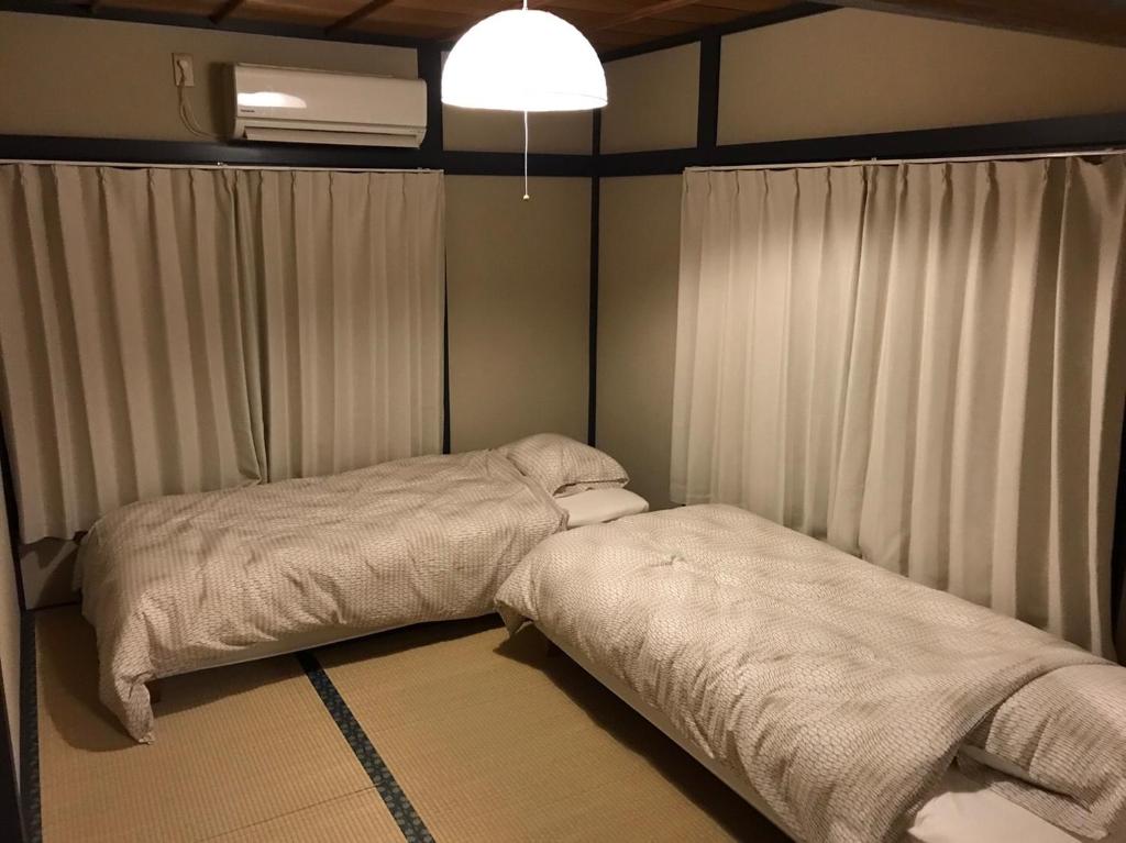 una camera con 2 letti, una finestra e un ventilatore di Rengeso a Tokyo