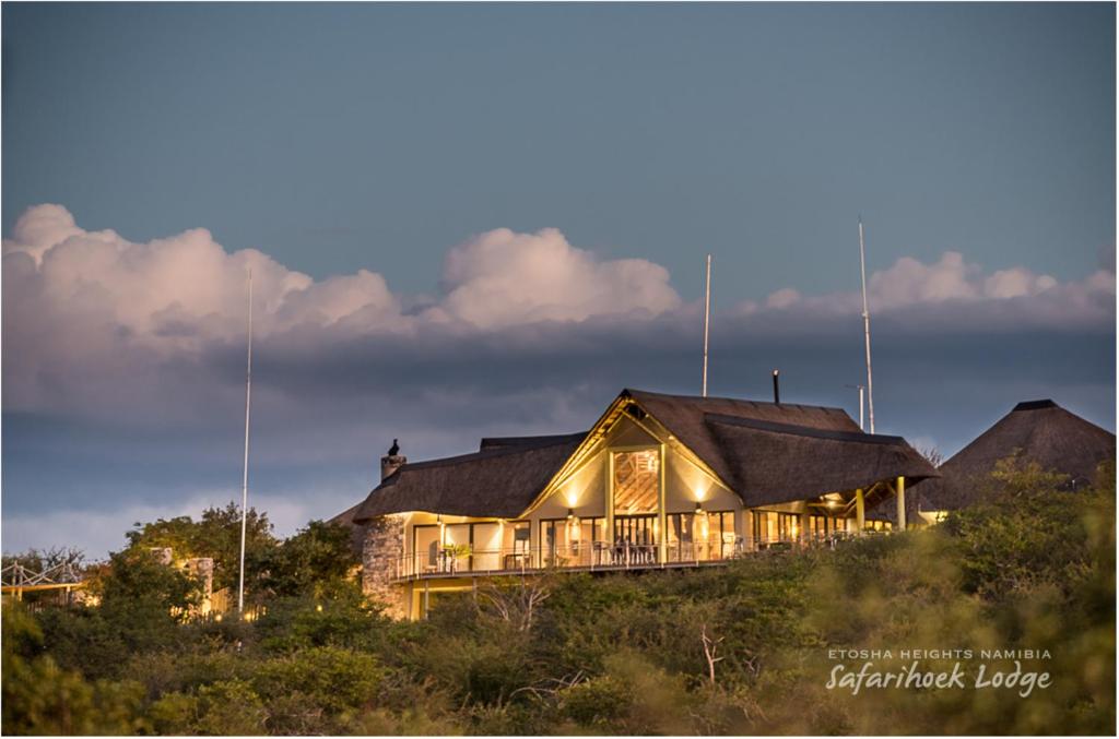 une maison au sommet d'une colline la nuit dans l'établissement Safarihoek Lodge, à Kamanjab